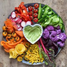 a heart shaped bowl filled with vegetables and veggies