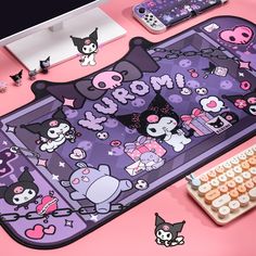 a pink desk with hello kitty stickers on it and various other items around it