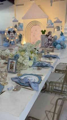 a table set up for a mickey mouse themed birthday party with blue and white decorations