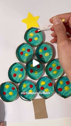 a person is painting a christmas tree made out of cupcakes