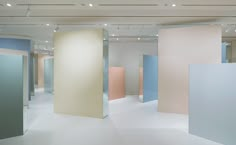 an empty room with multiple colored partitions in the center and lights on the ceiling