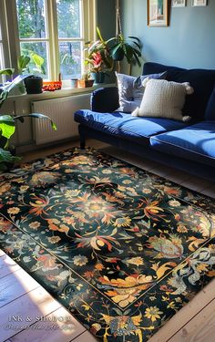 a living room with a blue couch and rug on the floor in front of a window