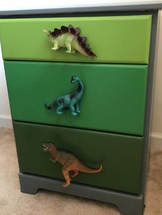 three drawers with dinosaurs painted on them in the same color as green and gray ones