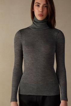 Long-sleeve high-neck tubular top made from a wool-silk blend. Fitted Elegant Merino Wool Tops, Fitted Merino Wool Tops For Layering, Elegant Fitted Merino Wool Tops, Stretch Merino Wool Turtleneck Top, Fitted Fine Knit Merino Wool Tops, Fitted Merino Wool Fine Knit Tops, Merino Wool Turtleneck Top, High Neck Merino Wool Tops For Fall, Elegant Merino Wool Tops For Winter