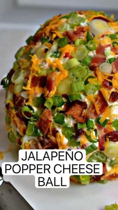 a cheese ball with bacon, lettuce and other toppings on it next to a knife