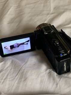 a black camera sitting on top of a bed