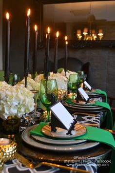 the table is set with black and white plates, green napkins, and candles