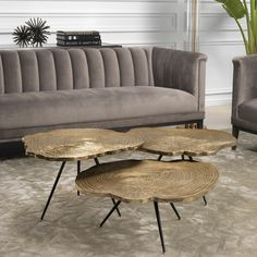 three coffee tables sitting on top of a rug in front of a couch and chair