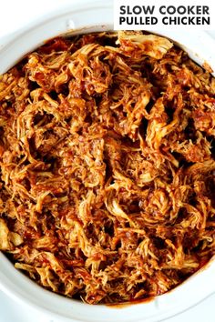 slow cooker pulled chicken in a white bowl with text overlay that reads slow cooker pulled chicken