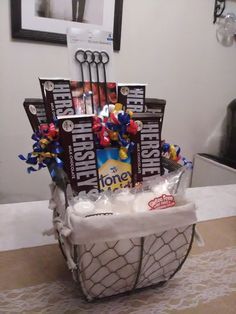 a basket filled with chocolates and candies on top of a table next to a wall