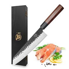 a large knife next to a box with some fish on it and spices around it