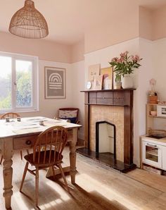 a dining room with a fireplace, table and chairs