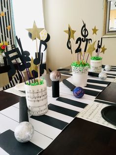 a table with black and white striped placemats, music themed centerpieces