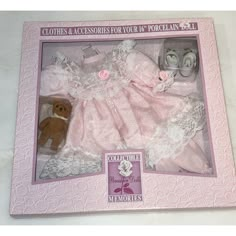 a baby doll in a pink box with white lace