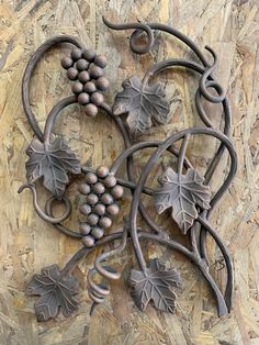 a metal sculpture with grapes and leaves on it