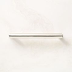 a chrome door handle on a white wall