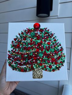 a painting of a christmas tree with red, green and gold ornaments on it's side