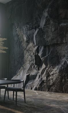 a table and chairs in front of a rock wall