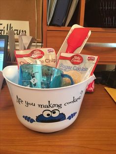 a bucket filled with personal care items sitting on top of a wooden table next to a laptop