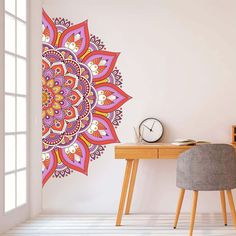 a room with a desk, chair and wall decal that has a colorful flower design on it