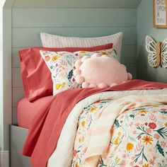 a bed with pink and white sheets and pillows