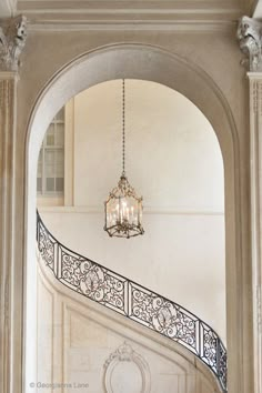 a chandelier hanging from the side of a staircase