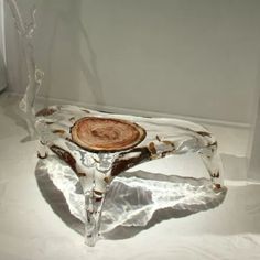 a glass table with a tree stump on it's side and branches sticking out of the top