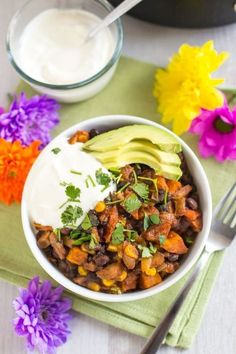 a bowl filled with beans, avocado and sour cream