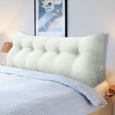 a bed with a white headboard and blue bedspread