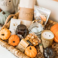 a basket filled with lots of different types of food and candles on top of a table