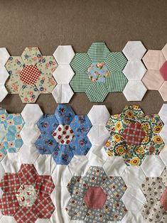 several hexagons are laid out on the floor to be quilted together