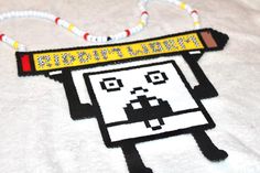 a white t - shirt with a cartoon character on it's chest and beaded necklace