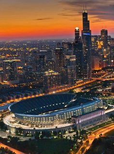 an aerial view of a large stadium in the middle of a city at night time