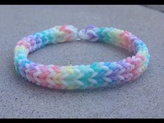 a bracelet made out of multicolored braiding on top of a cement surface