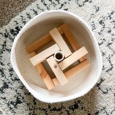 an aerial view of a wooden object in a white bowl on the floor next to a pair of scissors