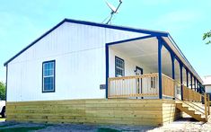 a small white house with blue trim and stairs