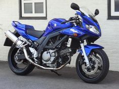 a blue motorcycle parked in front of a building