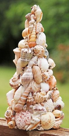 a small tree made out of seashells on top of a wooden fence post