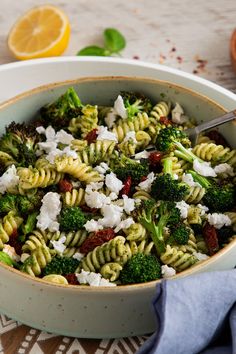 a bowl filled with pasta, broccoli and fettuccine on top of a table