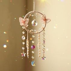 a dream catcher hanging from the ceiling with beads and butterflies on it's wings