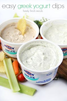 three cups filled with dips and vegetables