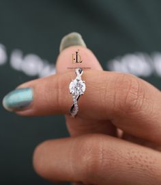 a woman's hand holding a diamond ring with the letter j on it, in front of a black background