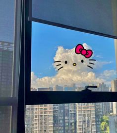 a window with a hello kitty sticker on it's side in front of a cityscape