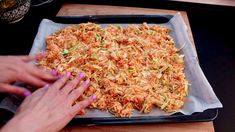 a person is making food on a tray with their hands and fingers in the middle