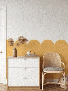 a white dresser sitting next to a yellow wall