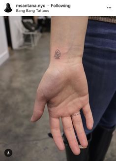 a person's hand with a small tattoo on it