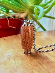 a small wooden object on a chain sitting on a table next to a potted plant