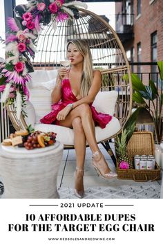 a woman in a pink dress is sitting on a white chair and drinking from a cup