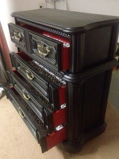 a black and red dresser sitting on top of a carpeted floor