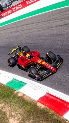 a man driving a red race car on a track